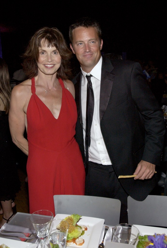 Suzanne Morrison, in a red dress, and Matthew Perry, in a black suit, stand side by side in a snap from 2002