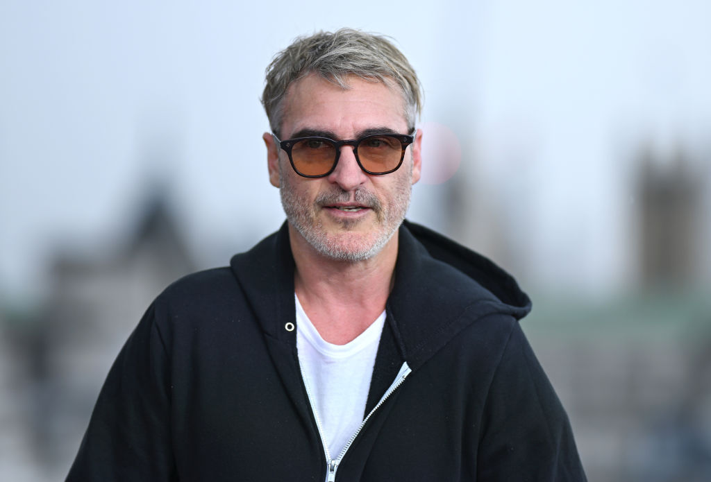 Joaquin Phoenix wearing red tinit sunglasses and a black hoody at the Joker Folie à Deux photocall