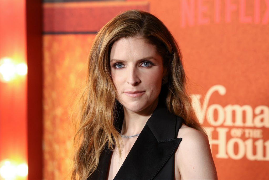 Anna Kendrick on the red carpet in black dress looking at camera 