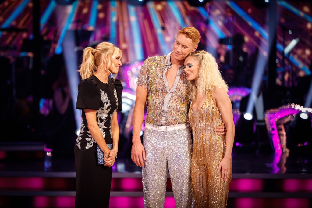 Tom Dean and Nadiya Bychkova comforting each other with a hug while speaking with host Tess Daly on Strictly Come Dancing.