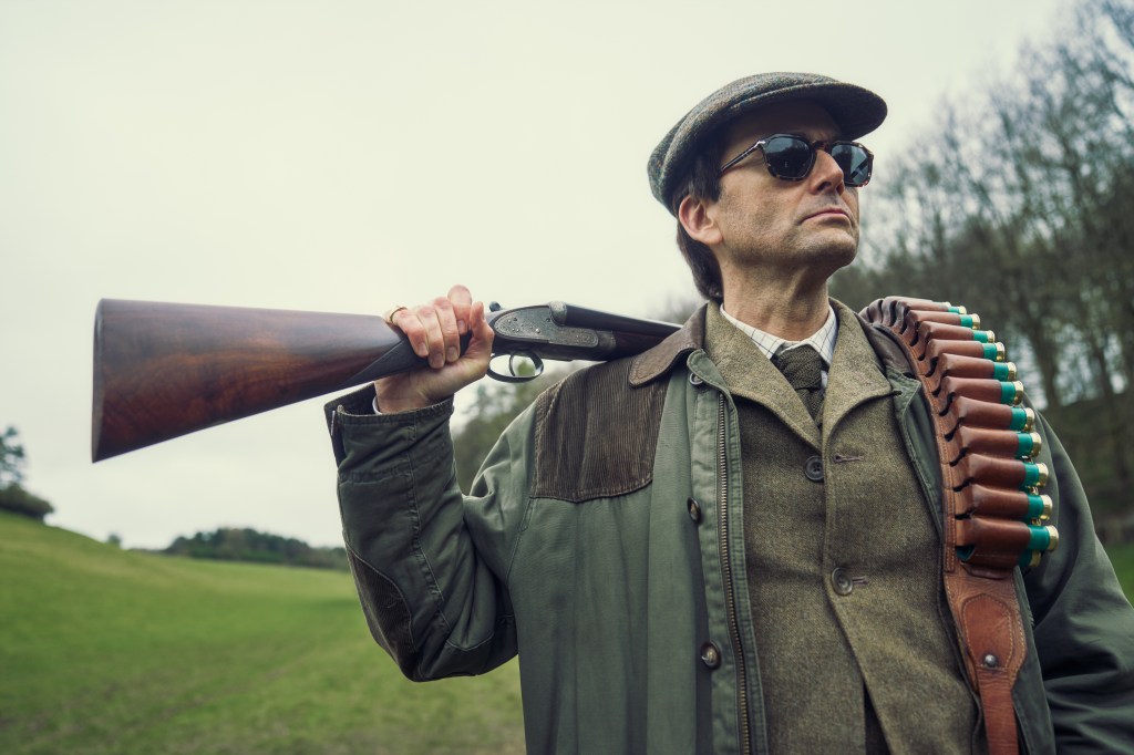 David Tennant as Lord Tony Baddingham holiding a rifle in Rivals