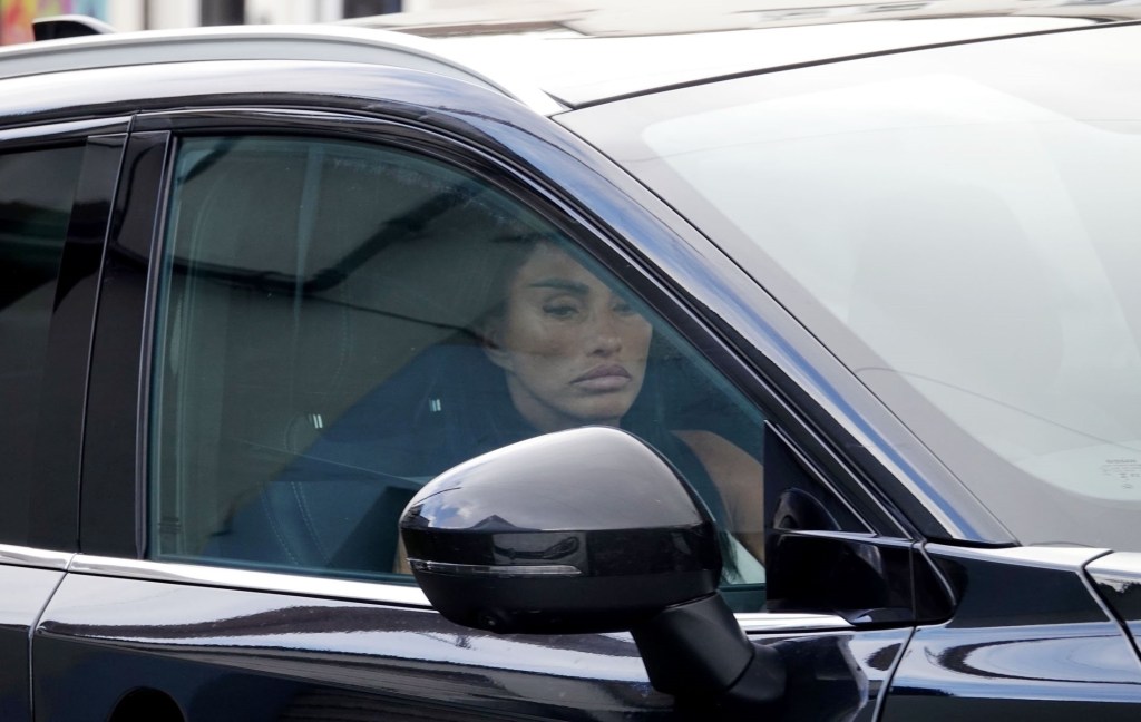 Katie Price looks glum behind the tinted window of a black car