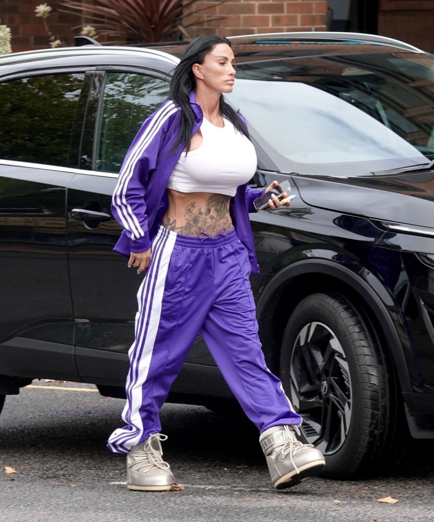 Katie Price wears purple tracksuit as she walks beside black car on street