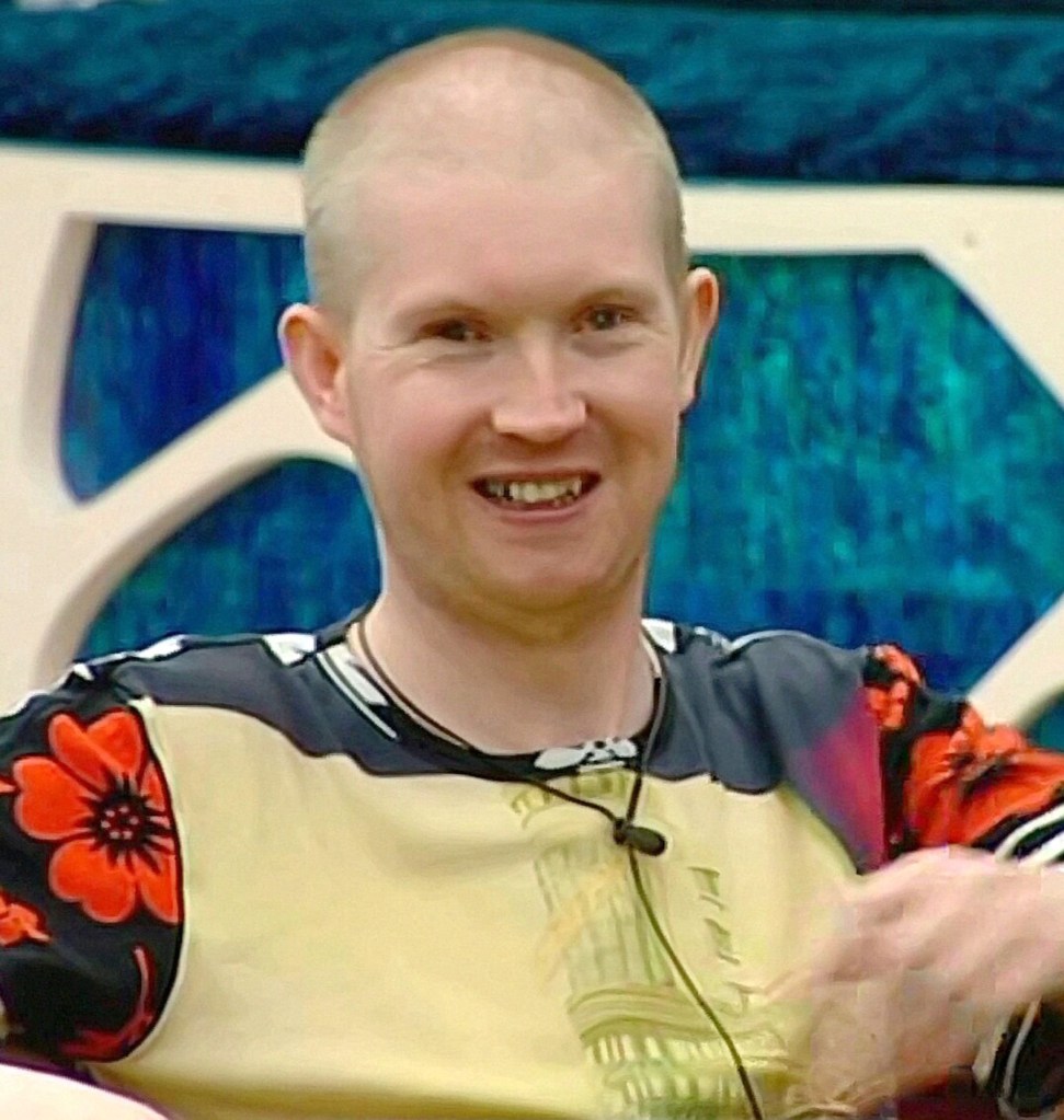 Mikey Hughes on Big Brother in 2008, smiling and wearing a patterned top