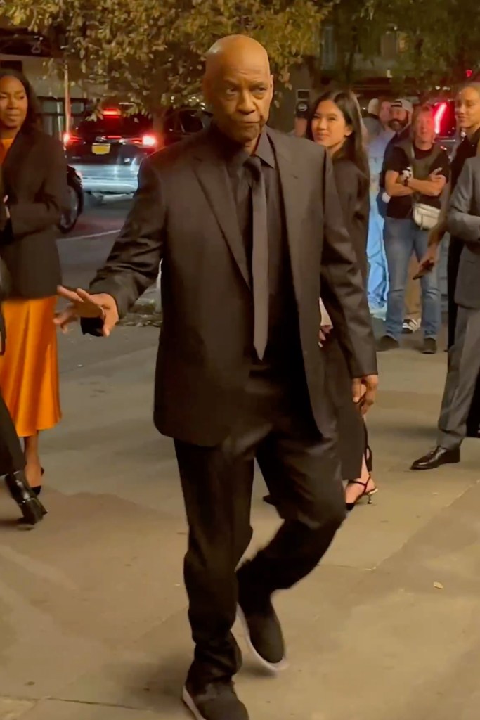 Denzel Washington walking in New York wearing a black suit