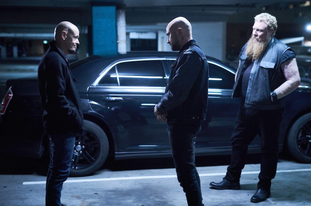 Scott Ryan as Ray Shoesmith speaks with two men in carpark in scene from Mr Inbetween